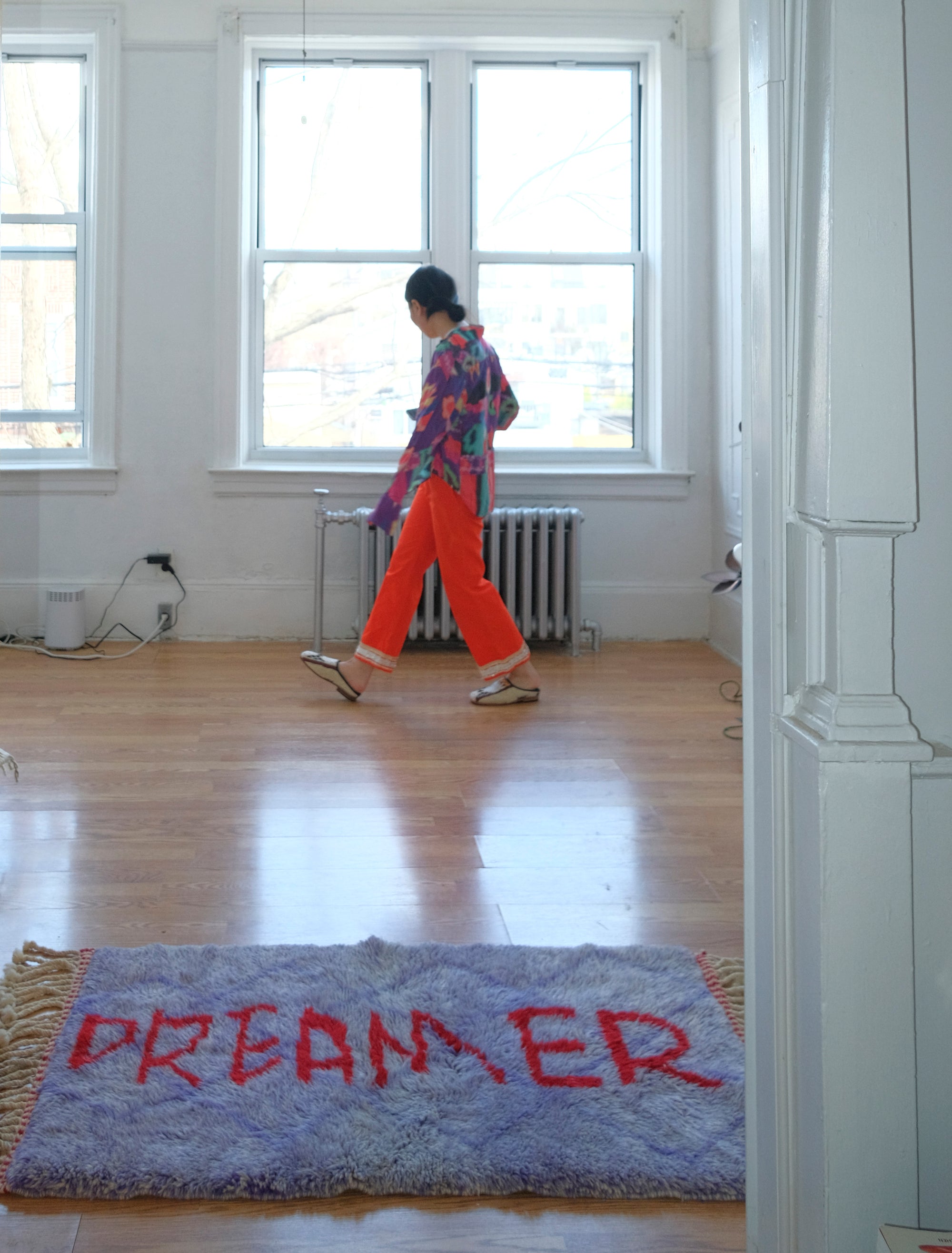 Experience the elegance of our 'Royal Dreamscape Rug,' featuring a handwritten 'Dreamer' in red yarn. The light purple base is intricately woven with a subtle Berber pattern, creating a truly unique and enchanting addition to your space. Elevate your decor with this regal blend of design and craftsmanship, where classic beauty meets artistic flair.