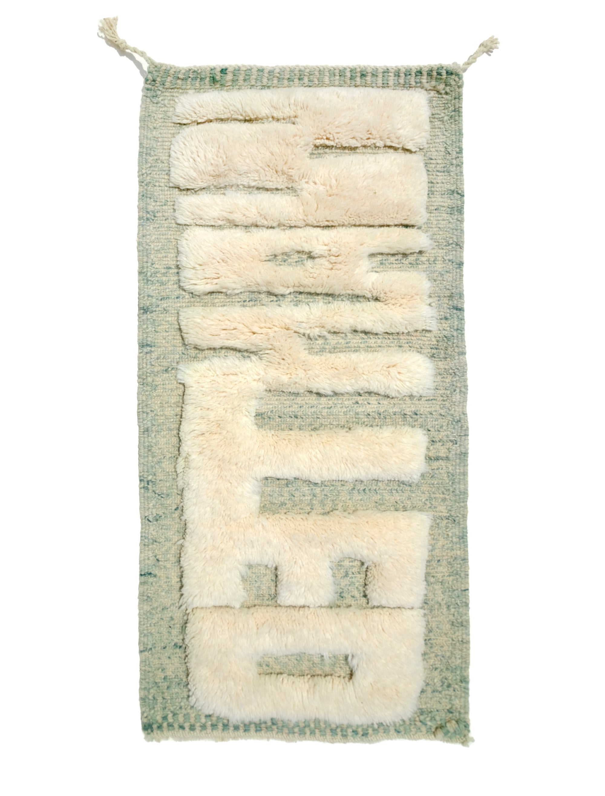Discover the Reversible Ivory Green Whispers Rug, a truly unique and versatile piece handmade by Berber women in the Atlas Mountains. With its fuzzy 'WANTED' lettering on one side and a calming mix of pale green shades on the other, this rug adds an elegant touch to your decor while spreading a positive message. Explore the beauty of reversible design in this exceptional handmade creation.