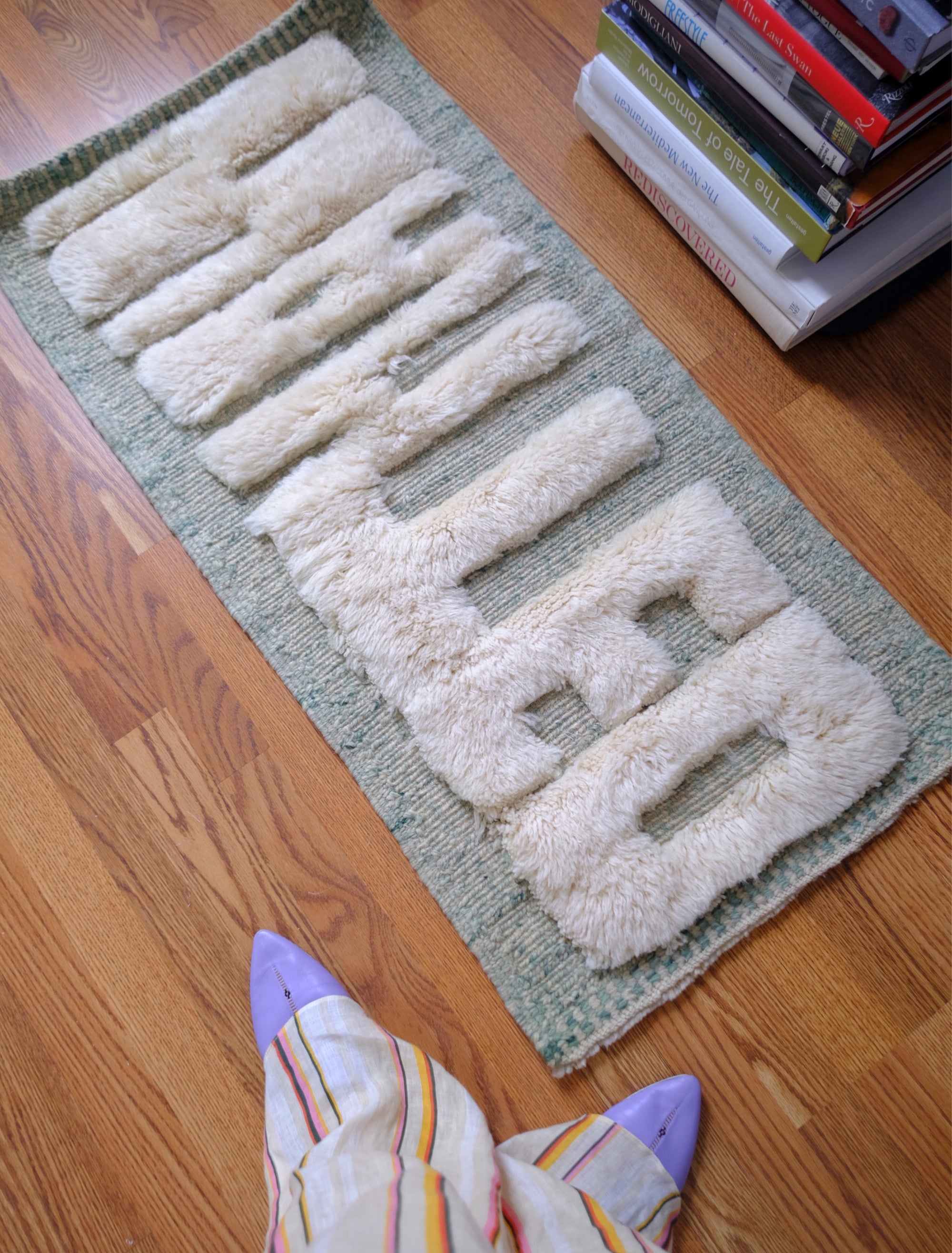 Discover the Reversible Ivory Green Whispers Rug, a truly unique and versatile piece handmade by Berber women in the Atlas Mountains. With its fuzzy 'WANTED' lettering on one side and a calming mix of pale green shades on the other, this rug adds an elegant touch to your decor while spreading a positive message. Explore the beauty of reversible design in this exceptional handmade creation.