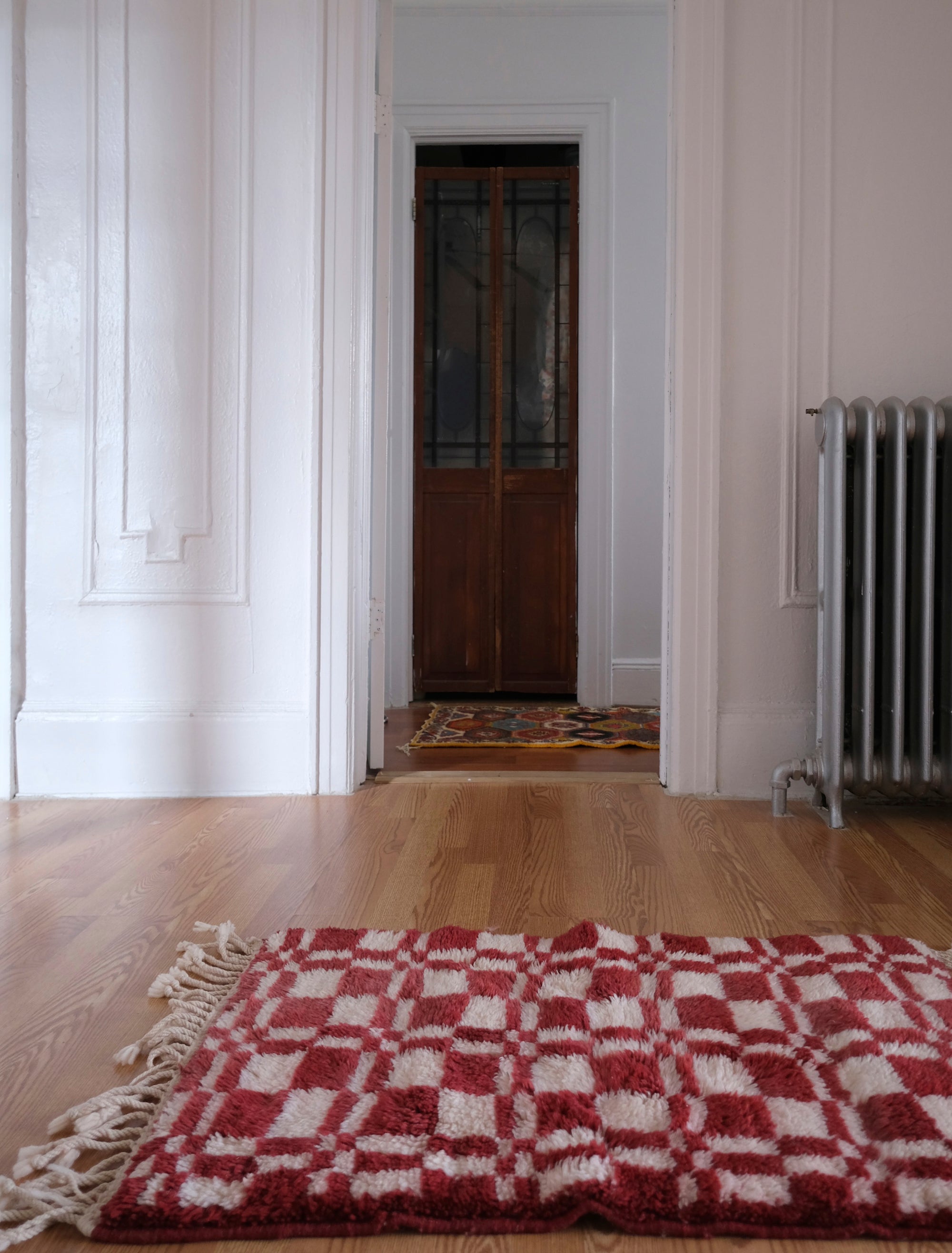 Introducing our 'Crimson Touch Chess Rug,' a beautifully crafted piece featuring a classic navy and ivory checkerboard pattern with a captivating crimson twist. Elevate your space with this rug that seamlessly blends sophistication with playfulness, adding a touch of timeless elegance and vibrant charm to your home décor.