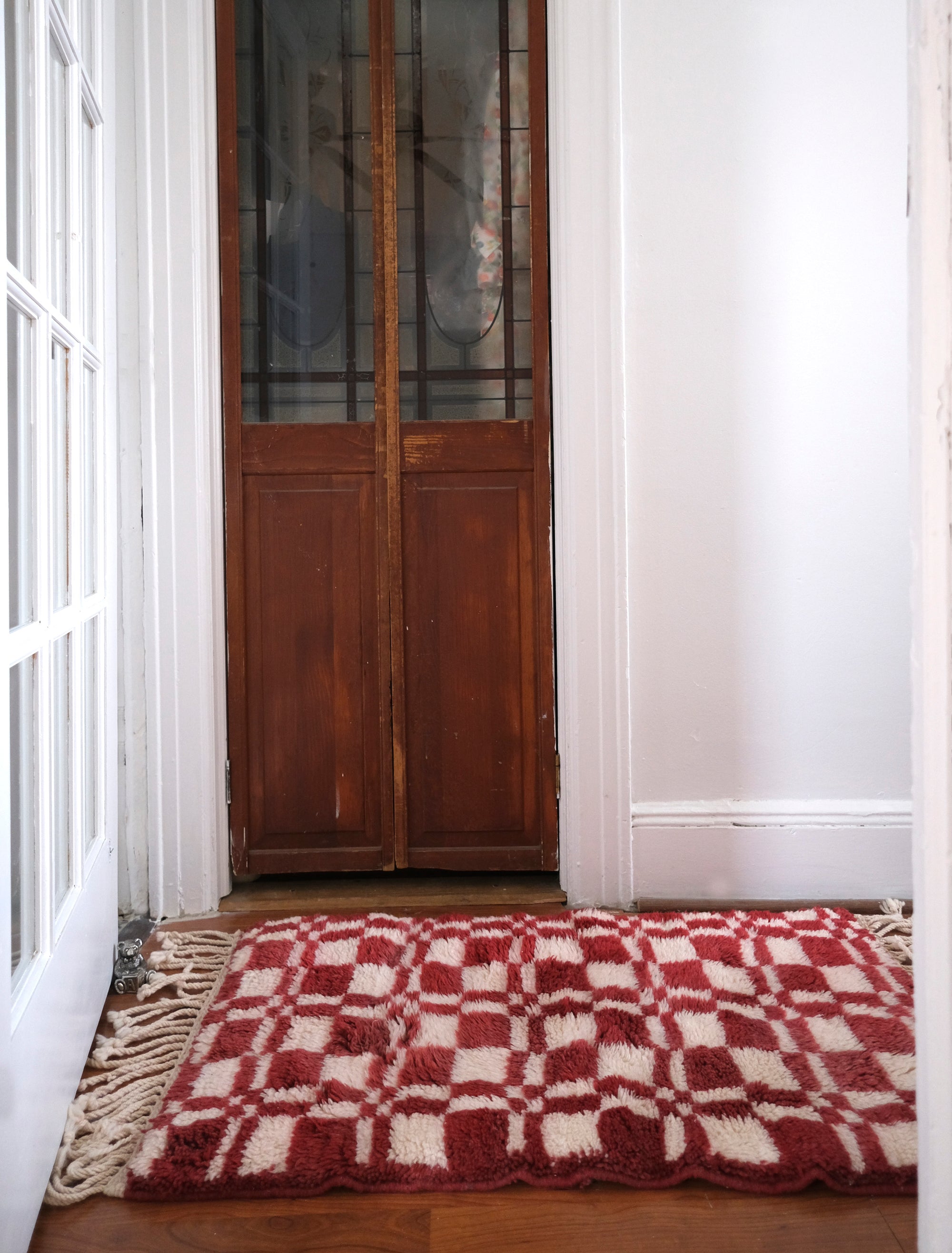 Introducing our 'Crimson Touch Chess Rug,' a beautifully crafted piece featuring a classic navy and ivory checkerboard pattern with a captivating crimson twist. Elevate your space with this rug that seamlessly blends sophistication with playfulness, adding a touch of timeless elegance and vibrant charm to your home décor.