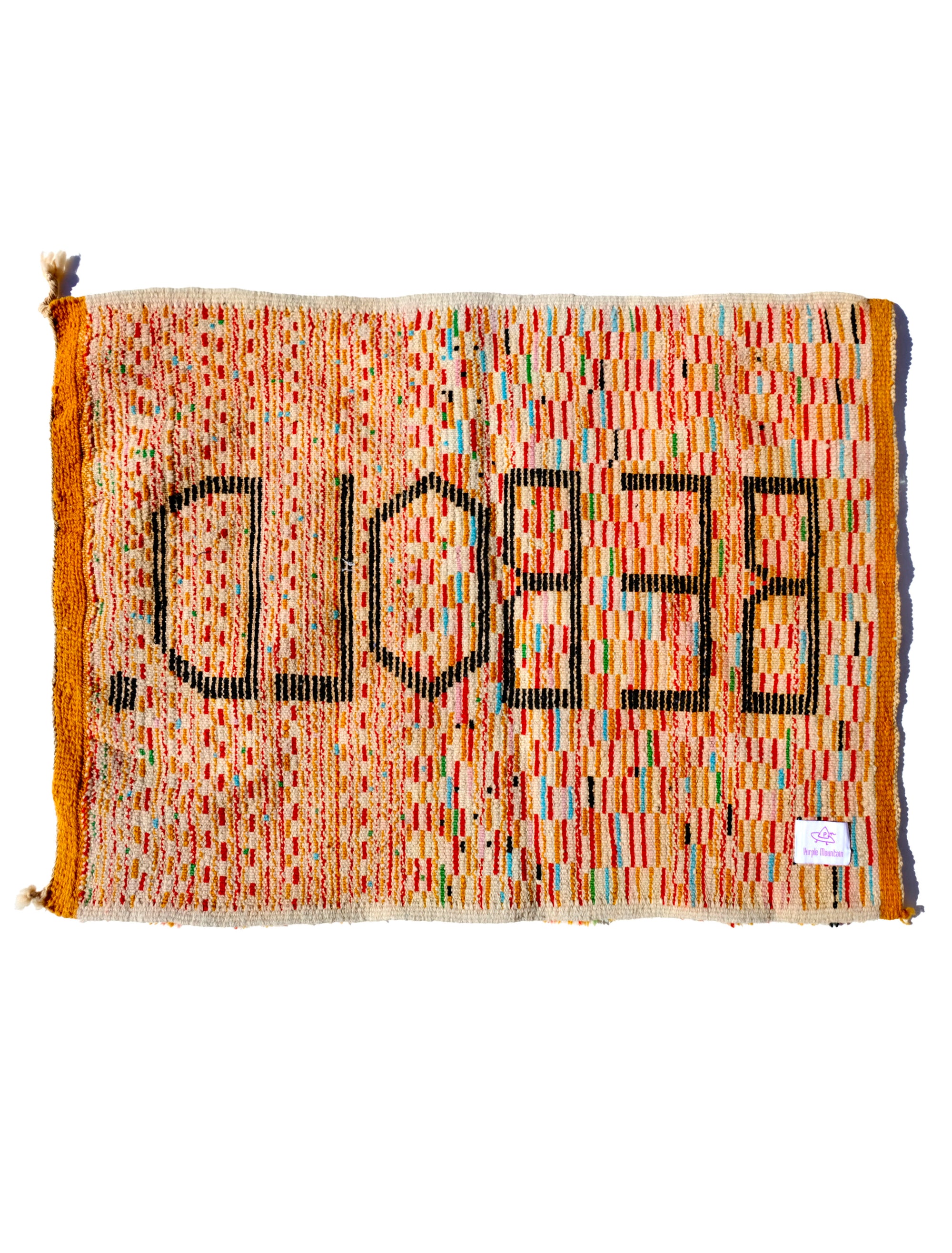 Elevate your space with the 'Tangerine Radiance Rug.' Handmade in the Atlas Mountains, this vibrant rug features a unique checkerboard pattern in warm tangerine tones. The focal point, proclaiming 'BE BOLD' in black letters, adds a touch of inspiration. With a fuzzy texture and meticulous craftsmanship, this rug brings warmth and positive energy to any room.  Size: 80 x 120cm / 31 x 47in 