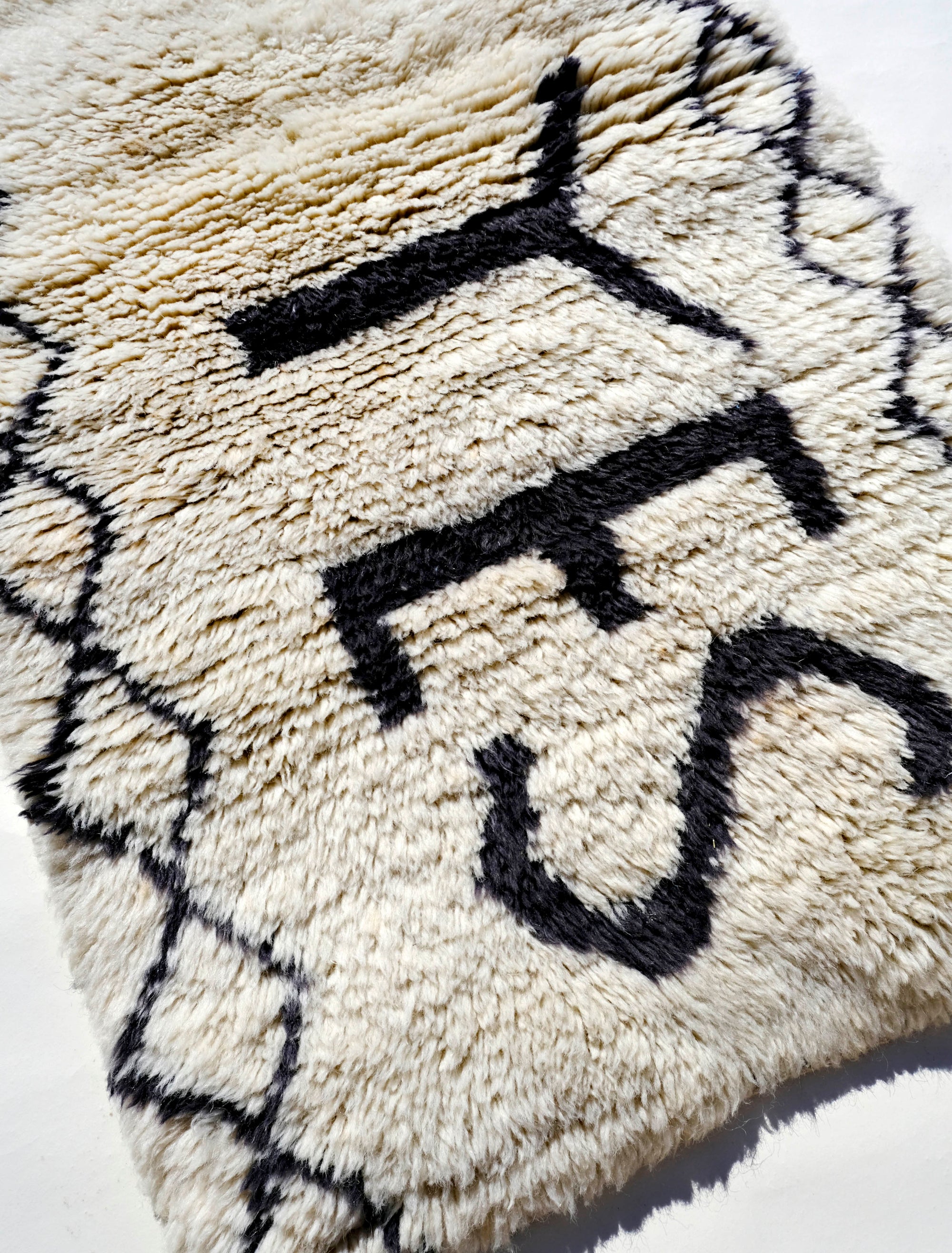 Infuse your space with positivity using the "Ivory In the Moment Rug." Handmade in the Atlas Mountains, its soft ivory base showcases the empowering phrase "NOW YES" at the center. Modern and Moroccan-inspired with small diamond patterns, this unique rug adds style and positivity to your home.