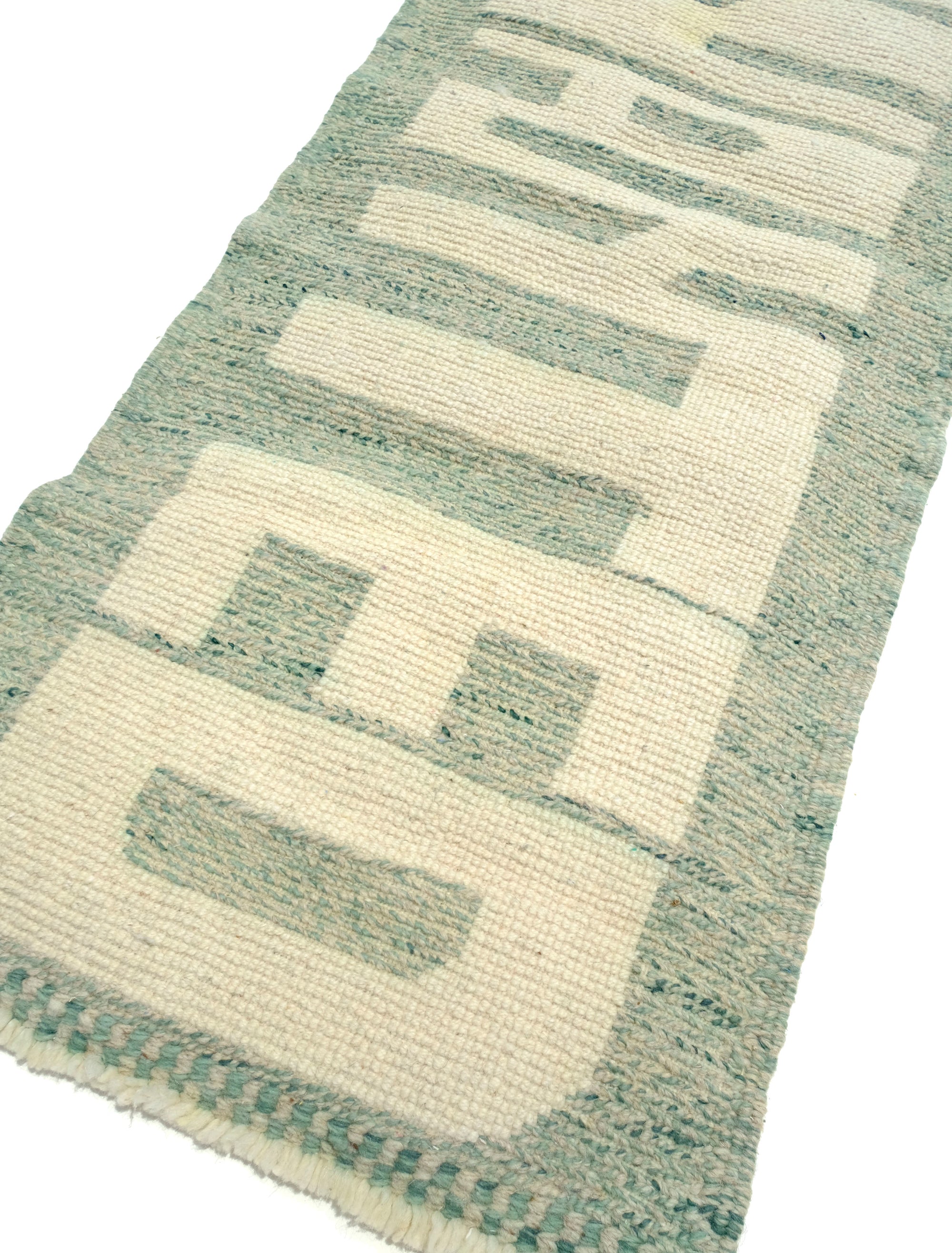 Discover the Reversible Ivory Green Whispers Rug, a truly unique and versatile piece handmade by Berber women in the Atlas Mountains. With its fuzzy 'WANTED' lettering on one side and a calming mix of pale green shades on the other, this rug adds an elegant touch to your decor while spreading a positive message. Explore the beauty of reversible design in this exceptional handmade creation.