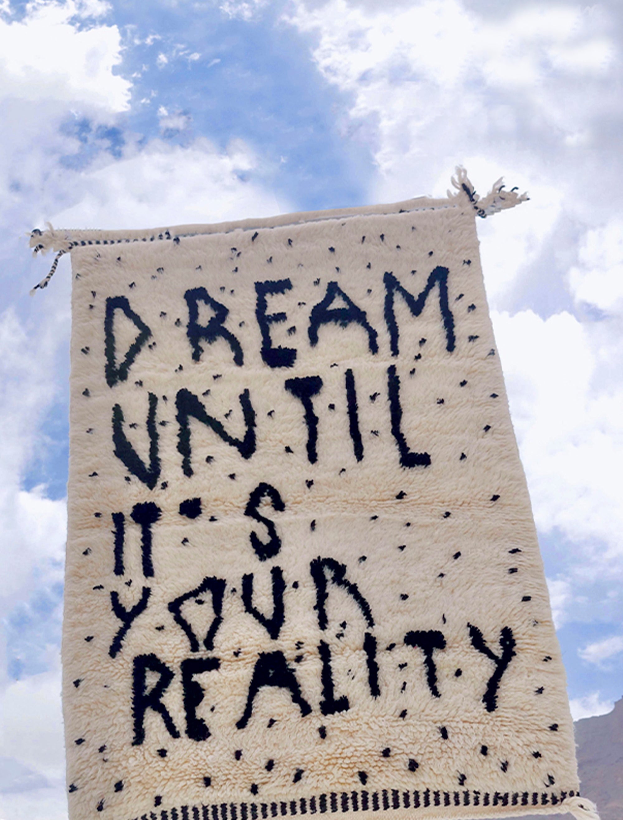 Experience the captivating allure of our Ivory Dreamscape Berber Rug, where the timeless charm of classic English script weaves a mantra of inspiration: "Dream Until It Is Your Reality." Immerse your space in this exquisite blend of classic design and motivational sentiment, transforming your home with an air of elegance and aspiration.