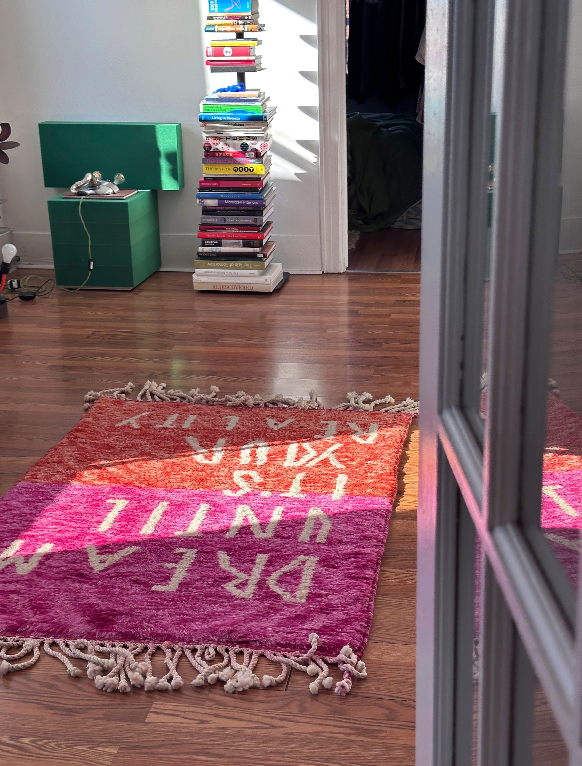 Introducing the enchanting 'Rosy Dreamscape Rug,' a delightful fusion of pink and red yarns forming a playful base, with the inspiring phrase 'Dream Until It Is Your Reality' expertly woven in white yarn. Elevate your space with this captivating blend of colors and motivational message, creating a joyful and imaginative ambiance that adds a touch of beauty and positivity to your home.