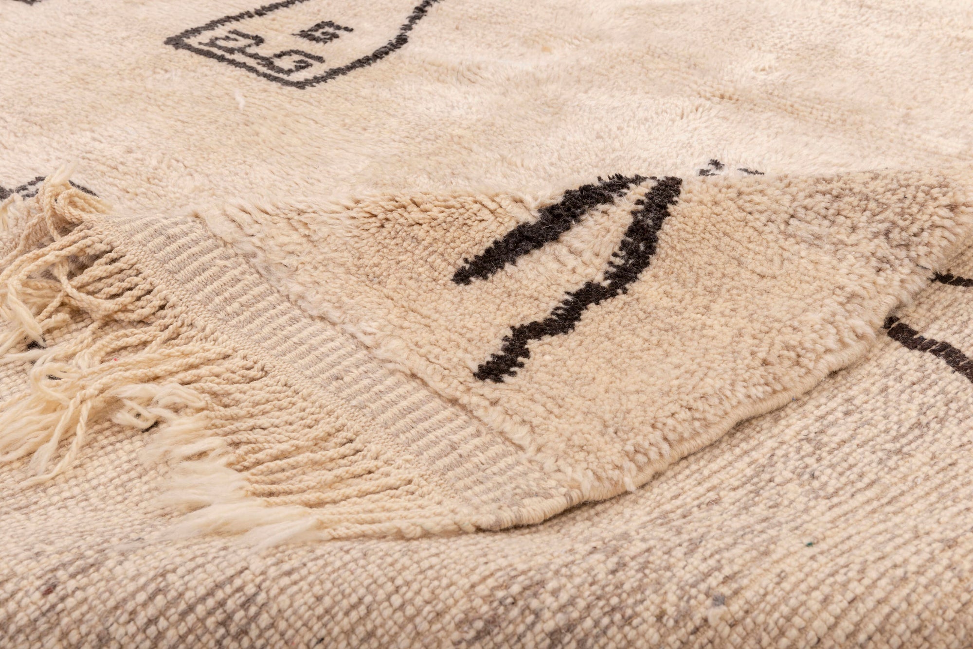 Transform your living space with our 'Ivory Homestead Berber Rug.' Crafted with an ivory base and adorned with abstract motifs reminiscent of houses and lines, this wool Berber rug brings a touch of cozy charm to your home decor.