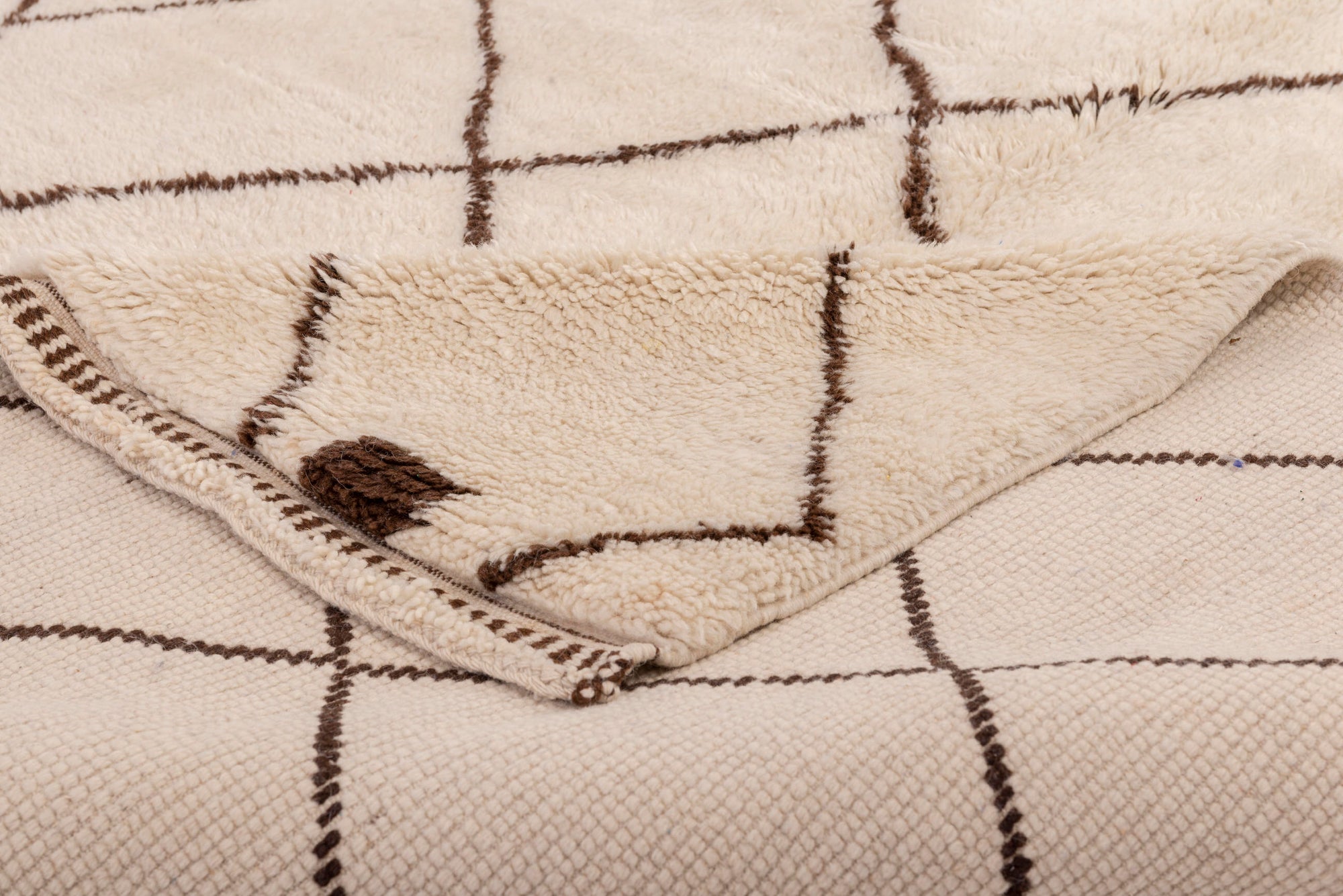 Elevate your space with our Ivory Crosshatch Beni Ourain Rug, featuring a classic ivory base with intricate crisscross brown lines meticulously handwoven in wool. Perfect for adding a touch of timeless elegance to your decor.