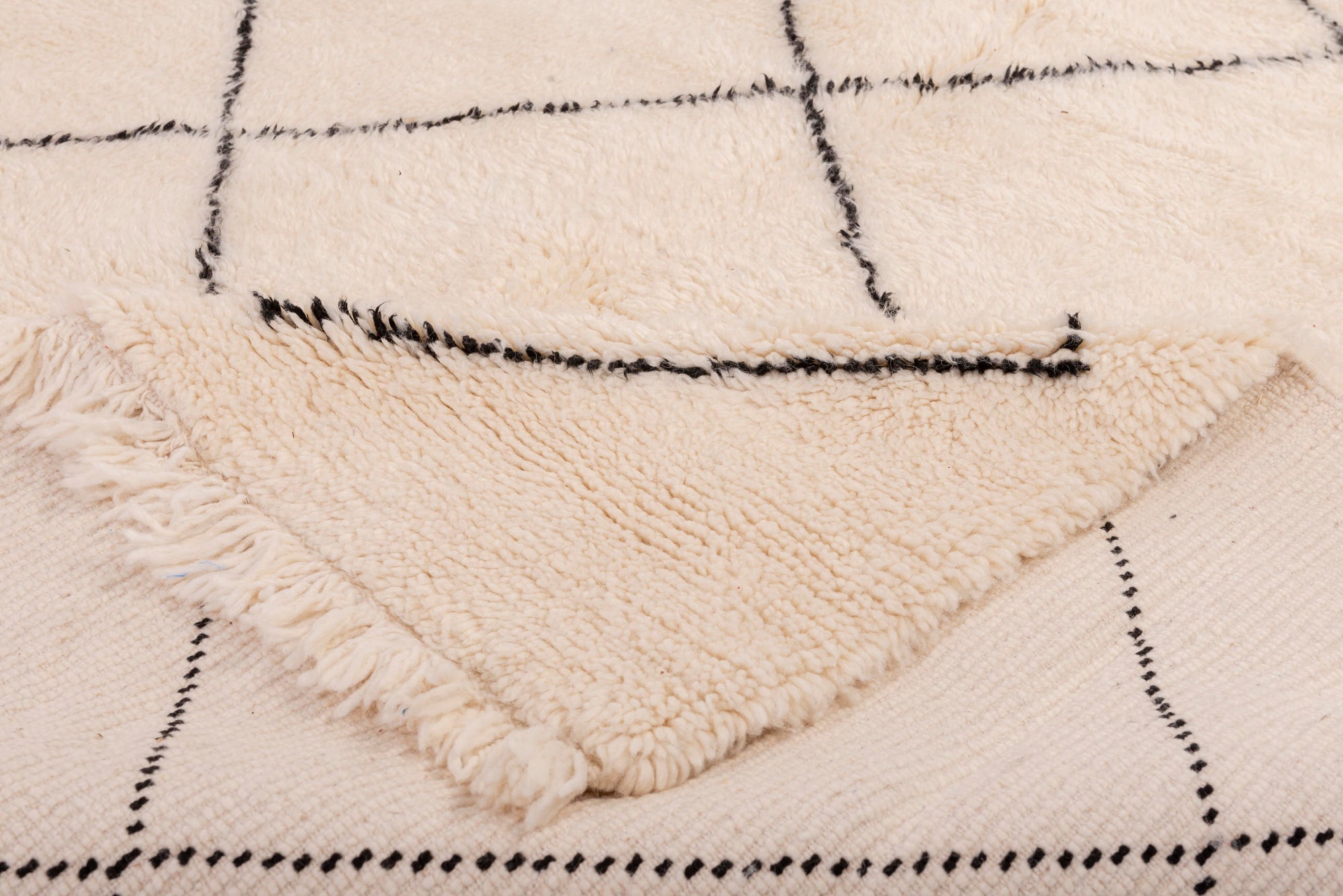 Elevate your space with our Ivory Classic Crisscross Beni Ourain Rug. This timeless piece features a traditional Moroccan crisscross design in ivory and black, adding warmth and sophistication to your decor.