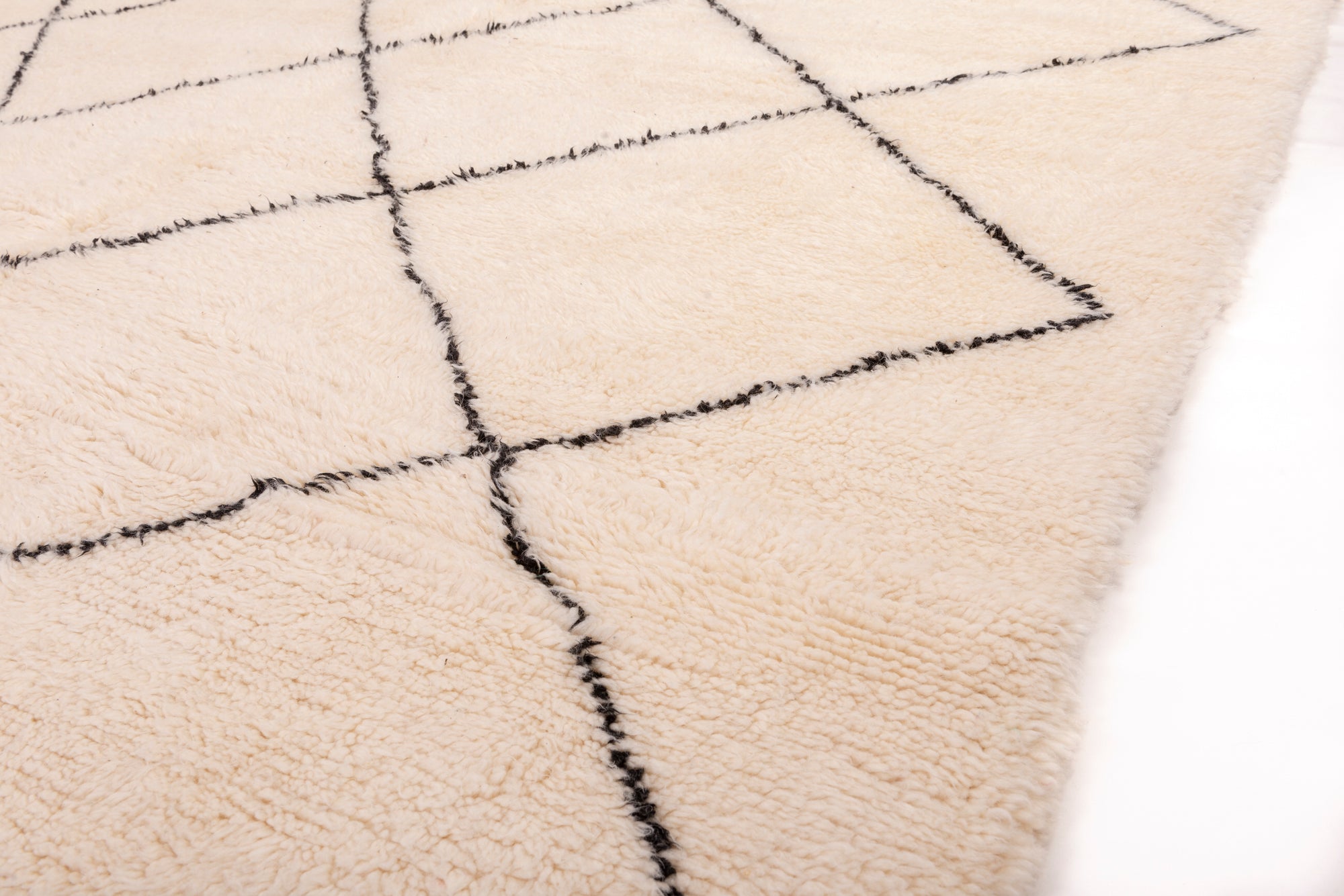 Elevate your space with our Ivory Classic Crisscross Beni Ourain Rug. This timeless piece features a traditional Moroccan crisscross design in ivory and black, adding warmth and sophistication to your decor.
