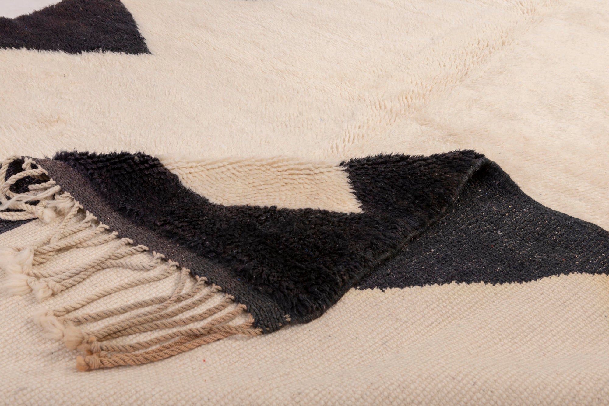 Elevate your space with our Ivory Triangle Border Beni Ourain Rug. This classic piece features a timeless ivory base adorned with a striking black triangle border, creating a harmonious blend of traditional Moroccan design and modern elegance. Crafted with care, this rug adds a touch of sophistication to your decor, making it a perfect addition to your home.