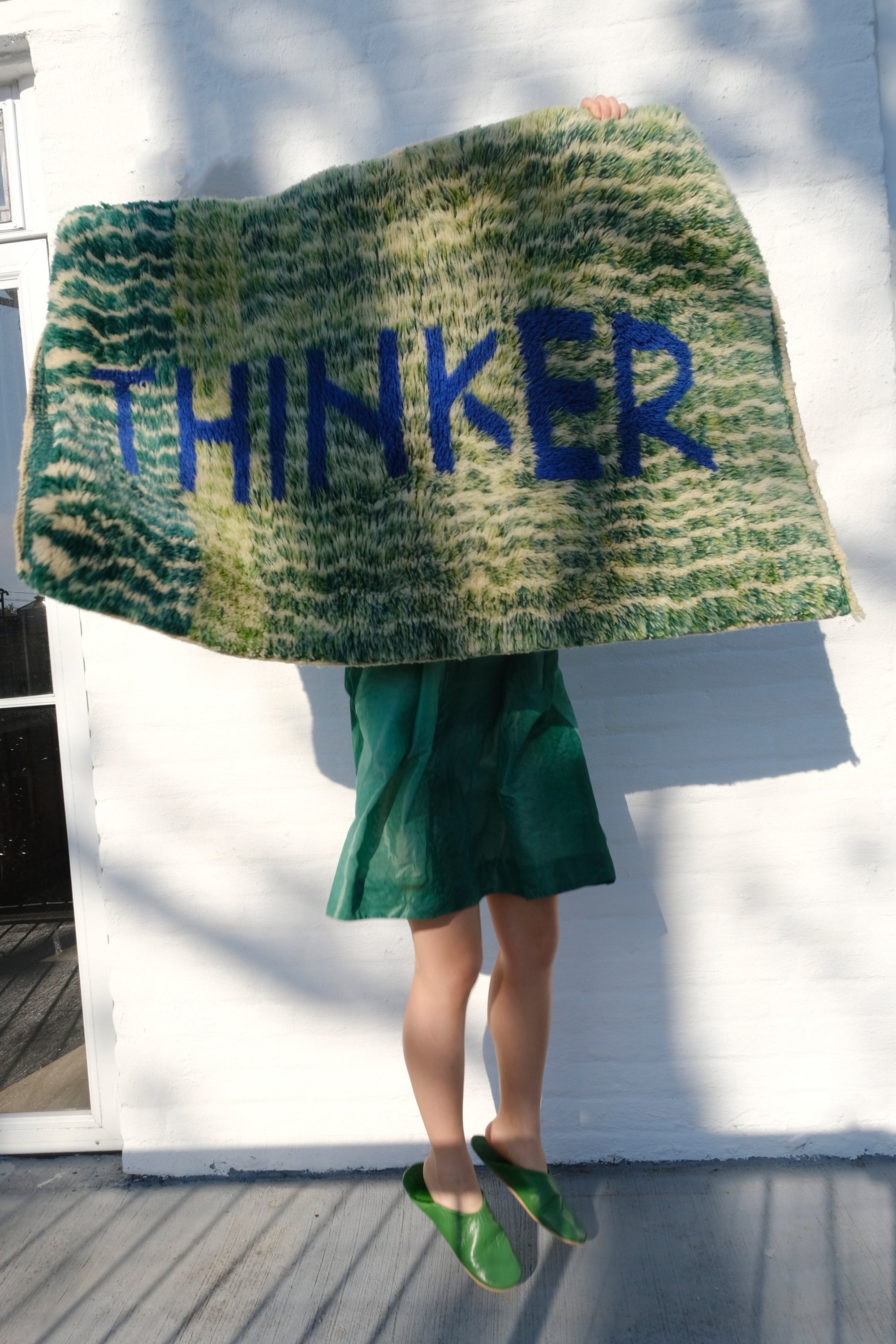 Introducing the 'Verdant Thinker Rug,' where the profound 'Thinker' letter is meticulously woven in blue yarn. Set against a backdrop of unique green and ivory curved wave lines, this rug brings a touch of intellectual charm to your space. Elevate your home with its artistic blend of colors and textures, creating a vibrant and thoughtful ambiance that resonates with modern sophistication.
