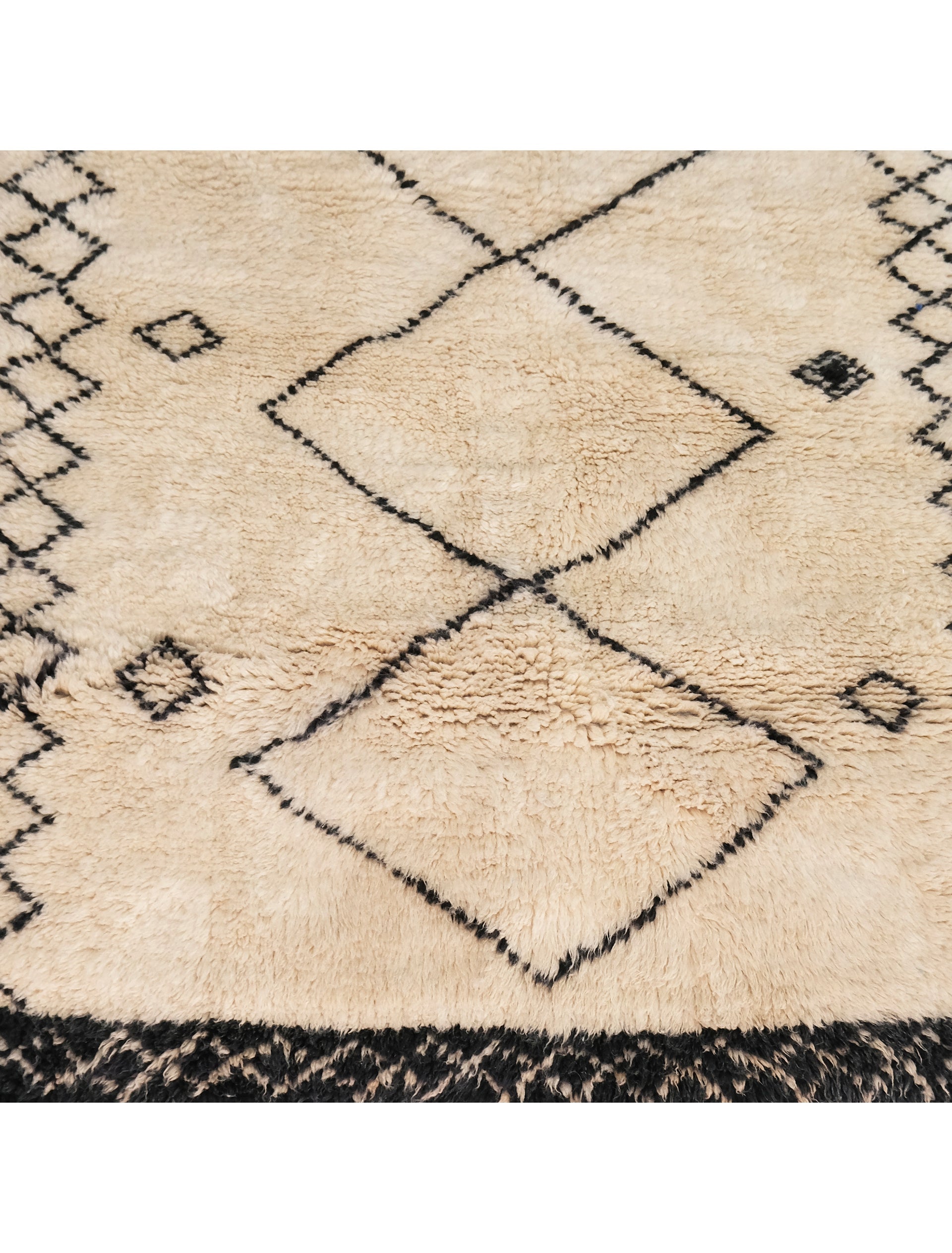 Discover elegance with our "Monochrome Diamond Ensemble" Beni Ourain Rug, sized at 3.7 x 4.9 feet. Its ivory base features three prominent diamond shapes in a delicate black outline at the center, complemented by two rows of smaller diamonds on each side. Meticulously crafted, this rug effortlessly blends tradition and modern design, making it a versatile and captivating addition to any space. Elevate your home with timeless Berber beauty.